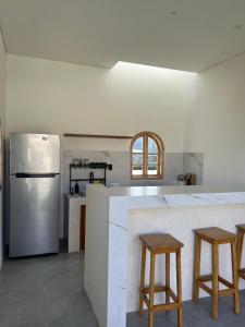 a kitchen with a counter with stools and a refrigerator at Sari Hills Bali in Nusa Dua