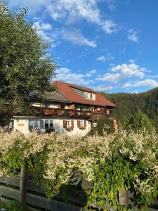 ein Haus in den Bergen mit einem Zaun und Bäumen in der Unterkunft Haus Mauken - Appartments mit Panoramablick in Murau