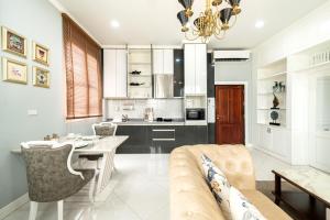 a kitchen and living room with a table and a couch at Niraxay Apartment in Vientiane
