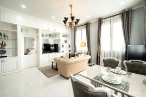 a living room with a table and a couch and a television at Niraxay Apartment in Vientiane