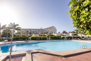 Una gran piscina con un hotel al fondo en Deluxe Solycan - by Gestión Vacacional Canarias, en Maspalomas