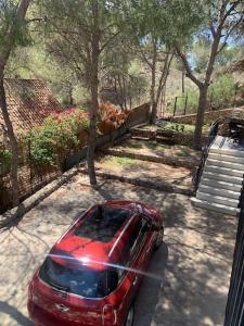 a red car parked in a parking lot at La Casa de la Fuensanta in Murcia