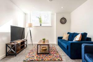 ロザラムにあるSmart 1 Bedroom Apartment in Central Rotherhamの青いソファとテレビのあるリビングルーム
