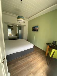 a bedroom with a white bed and a table at De Tussenstop in Villefranche-sur-Saône