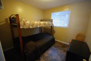 a bedroom with a bunk bed and a window at Wu Wu's Cabins in Wasaga Beach