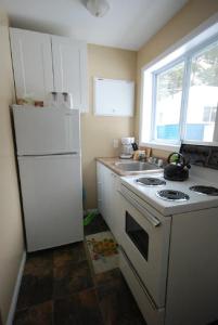 a kitchen with a white stove and a white refrigerator at Wu Wu's Cabins in Wasaga Beach
