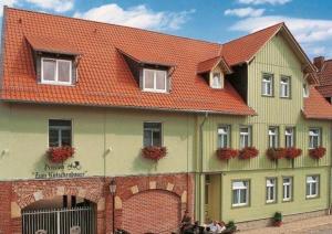 un grande edificio verde con tetto rosso di Pension Alter Kutschenbauer a Wernigerode