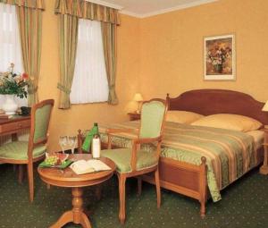 una camera d'albergo con un letto, un tavolo e delle sedie di Pension Alter Kutschenbauer a Wernigerode