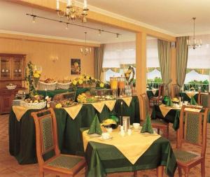una sala da pranzo con due tavoli con tovaglie verdi di Pension Alter Kutschenbauer a Wernigerode