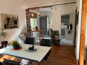 a kitchen and living room with a table and chairs at Sandys Cozy Stone Cottage in Maulbronn