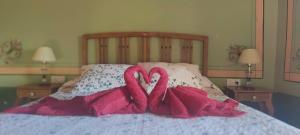 two heart shaped towels on top of a bed at Casa Rural Abuela Luci in Santibáñez de Béjar