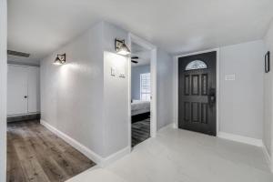 an empty hallway with a black door and a bedroom at Luxurious 5BR 2BA Holiday Home with Pool, Grill, Sauna & Game Room in The Colony
