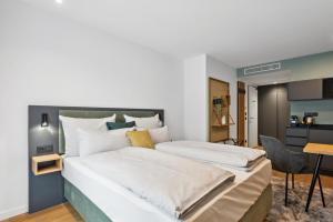 a bedroom with a large bed with white sheets at Nena Apartments München City in Munich