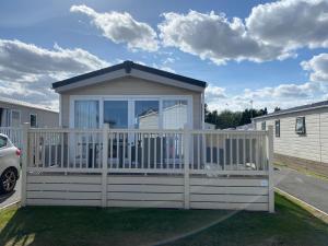 a gazebo with a white fence in a yard at 59 Cliff Field in Hopton on Sea