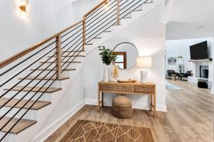 a living room with stairs and a table with a lamp at Lakefront Luxe 6BR 4,5BA Holiday Home with Pool & Hot Tub in Rowlett