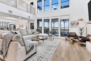 a living room with white furniture and large windows at Lakefront Luxe 6BR 4,5BA Holiday Home with Pool & Hot Tub in Rowlett