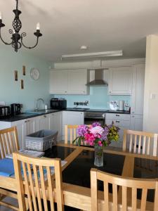 a kitchen with a dining table with flowers on it at B2 Waterfoot Apartment in Newcastle