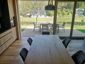 a wooden table and chairs in a room with a patio at House Natura Savica in Bohinj