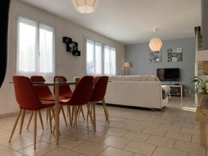 a living room with a table and chairs and a bed at Maison aux portes de Chambord in Saint-Laurent-des-Eaux