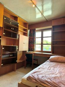 a bedroom with a bed and a desk and a window at Haus mit Pool im Herzen Bochums in Bochum