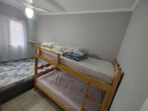 a small bedroom with two bunk beds in it at Apartamento com piscina! in Samaritá