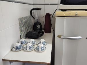 a group of cups and a blender on a counter at Apartamento com piscina! in Samaritá