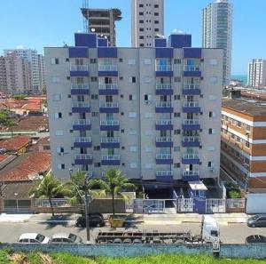 a large building with blue windows in a city at Apartamento com piscina! in Samaritá