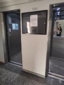 two elevator doors in a building with a woman standing behind them at Apartamento com piscina! in Samaritá