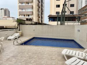 a swimming pool on the side of a building at Apartamento com piscina! in Samaritá