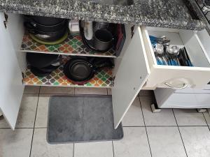 a kitchen drawer with pots and pans and a sink at Apartamento com piscina! in Samaritá