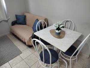 a table with blue chairs and a vase of flowers on it at Apartamento com piscina! in Samaritá