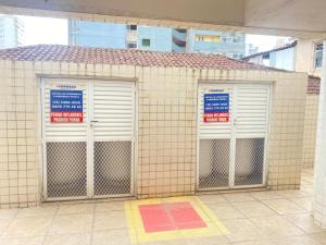 three metal doors on a building with signs on them at Apartamento com piscina! in Samaritá