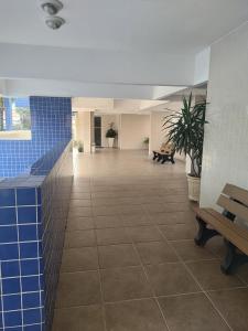 a hallway with blue tiles and benches in a building at Apartamento com piscina! in Samaritá