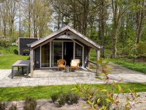 a small cabin with two chairs and a table at Vakantiepark Drentse Vennen in Een-West