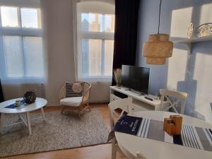 赛巴特班森Villa Gertrud, nur 300m zum Strand, inkl WLAN的配有电视、桌椅的客厅