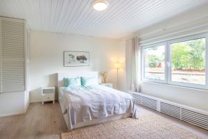 una camera da letto bianca con un letto e una finestra di Gunnarsstrand Surf House a Hanko