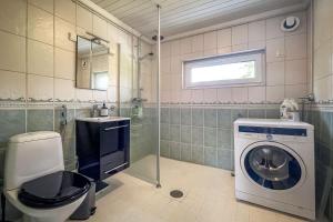 un bagno con lavatrice e lavandino di Gunnarsstrand Surf House a Hanko Altre 14 foto