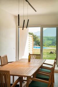 a dining room with a wooden table and a large window at Gutshof Ebner in San Paolo