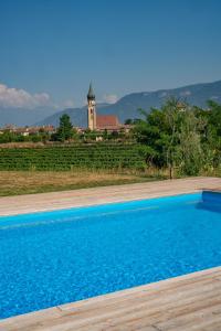 a blue swimming pool with a building in the background at Gutshof Ebner in San Paolo