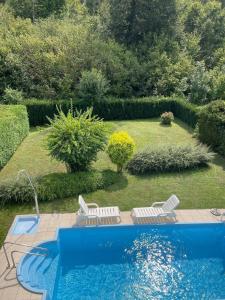 a swimming pool in a yard with chairs and a garden at Ferienhaus Casa Maria in Klagenfurt am Wörthersee in Waltendorf