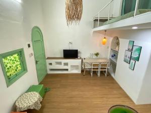 a living room with a table and a green door at Family House with Garden in Thôn Lại Thê