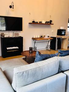 un soggiorno con un divano e una televisione di Walnut Cottage a Clarens