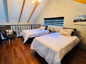 a room with two beds and a chair in it at Walnut Cottage in Clarens