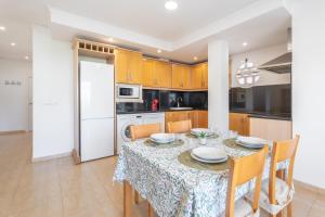 a dining room with a table and a kitchen at Mont Pele in Cullera