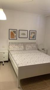 een bed in een slaapkamer met drie foto's aan de muur bij Los Cristianos Apartamento en residencial Los Seres in Los Cristianos
