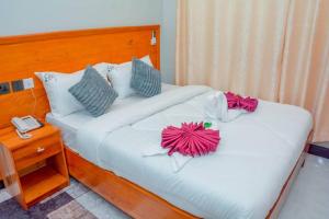 a bedroom with two beds with flowers on them at Kamur Executive Inn in Dodoma