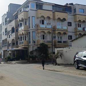 Ein Mann, der vor einem großen Gebäude die Straße hinuntergeht. in der Unterkunft Zen Horizon in Grand Médina