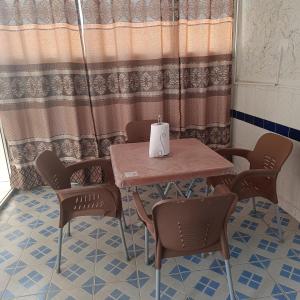 einen Tisch und Stühle in einem Zimmer mit einer Kerze darauf in der Unterkunft Zen Horizon in Grand Médina