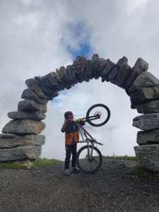 a man holding a bike in front of a stone arch at Michls Hoamat Dreibettzimmer in Sölden