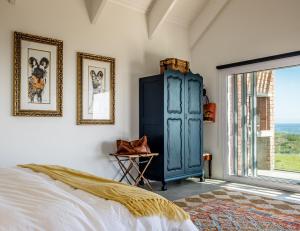 een slaapkamer met een blauwe kast en een raam bij Salt Duyker Eiland in St Helena Bay +15 foto's